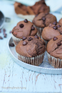 Chocolate Muffins sitting on a metal tray on a wooden table.